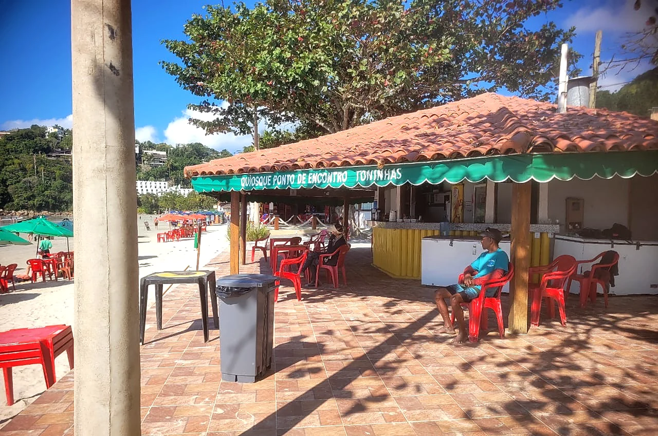Fachada do quiosque com telhado de telha e toldo verde na Praia das Toninhas