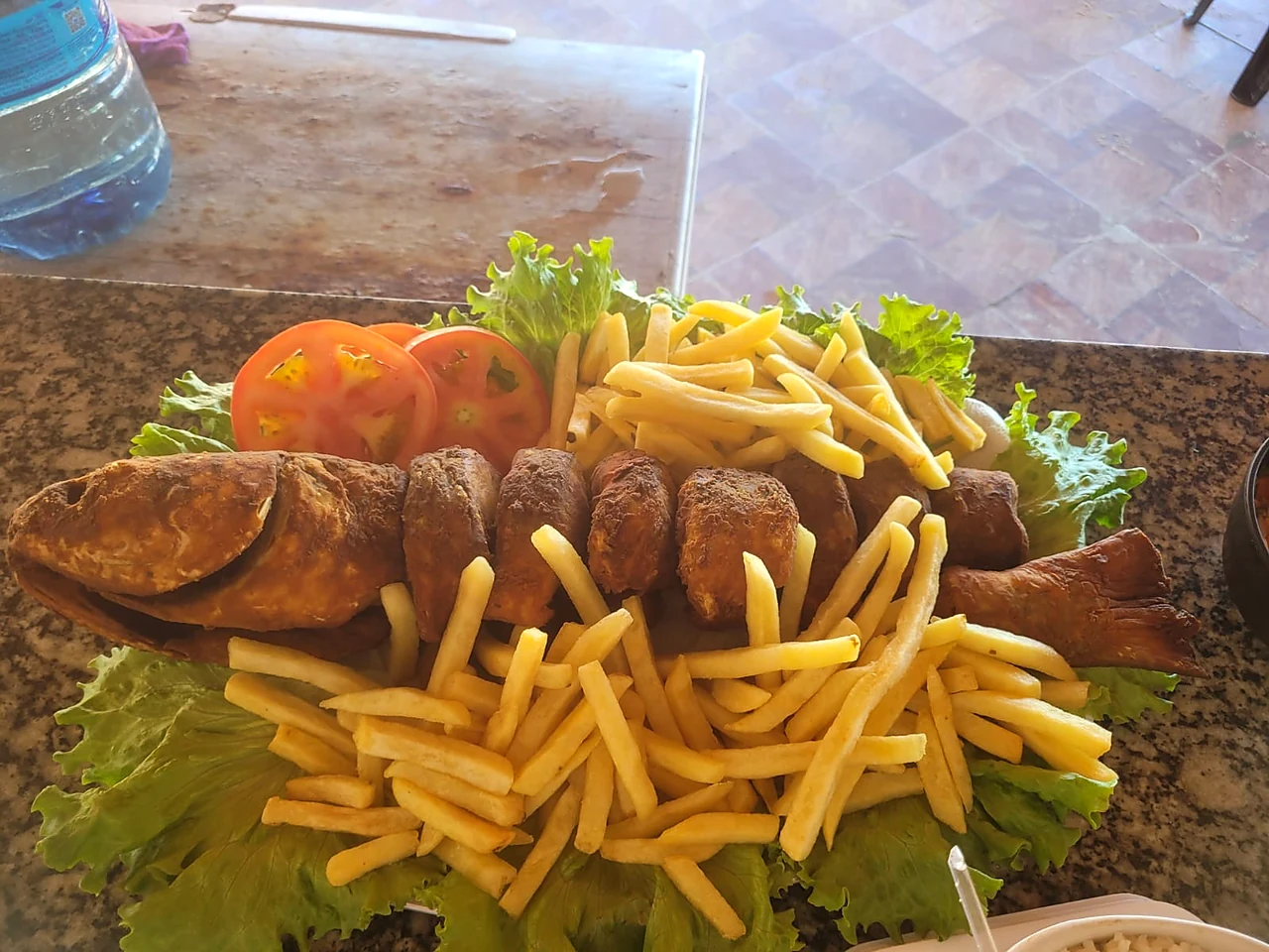 Peixe inteiro frito com batata e tomate